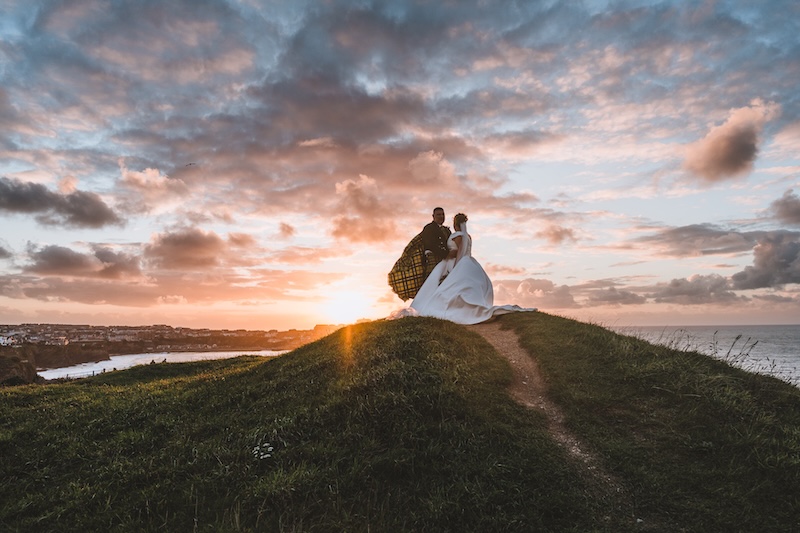 Couple during portrait session, with sunset coastline