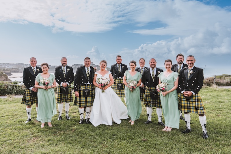 Wedding group photo with Cornwall coastline as the backdrop