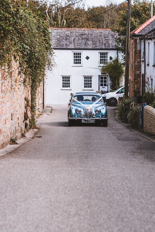 Wedding car arriving at the church with the bride adn her father
