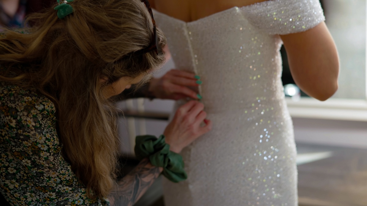 Bride having her dress fastened - leica wedding photography