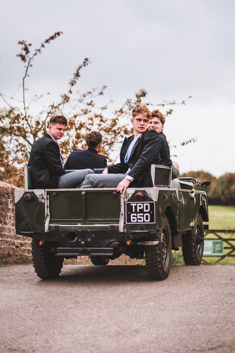 Groomsmen arriving the ceremony in an old Landrover