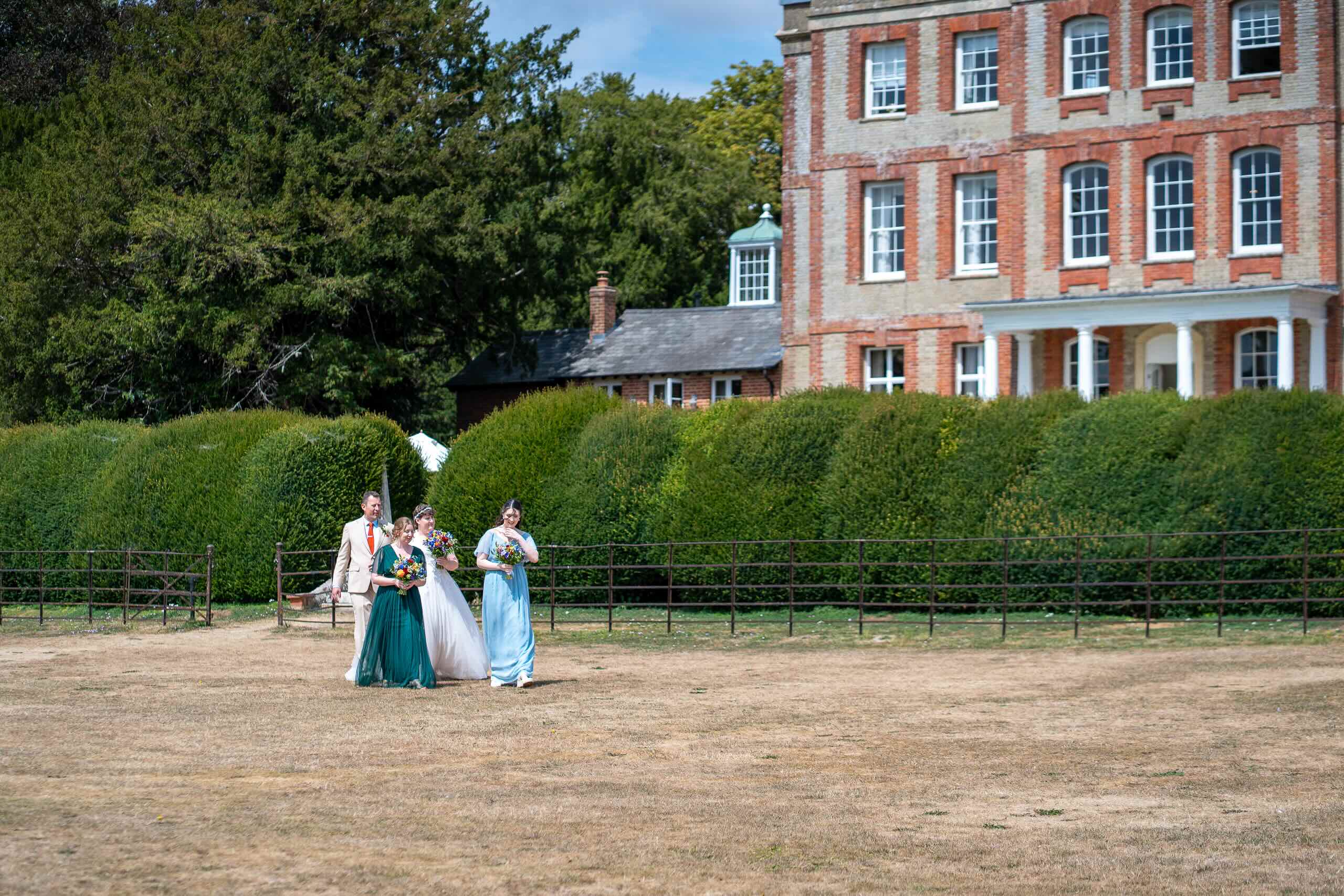 Wedding party walking across the grounds at Ardington House in Oxfordshire